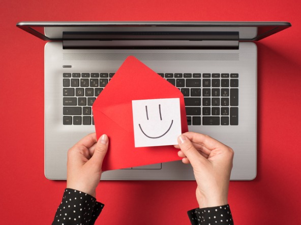Envelope with a smiley face on laptop